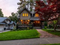 brown and white wooden house near green trees under white sky