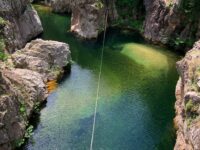 person walking on a rope over body of water