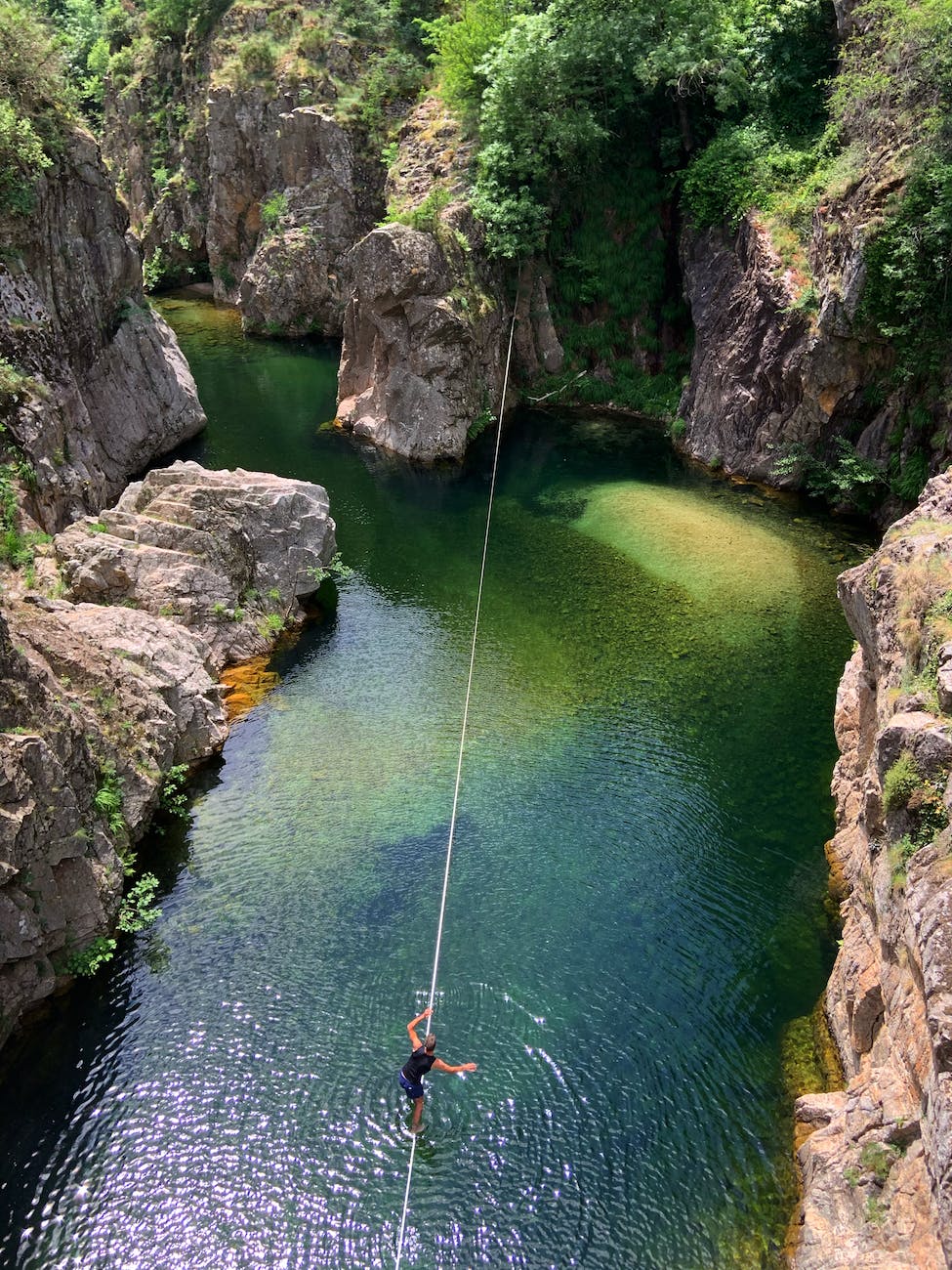 person walking on a rope over body of water